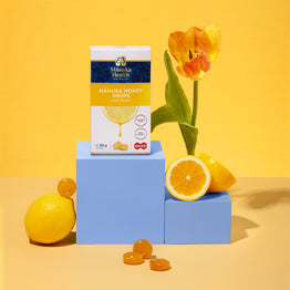 Manuka Health Manuka Honey Drops packaging with lemons and a tulip on a yellow background