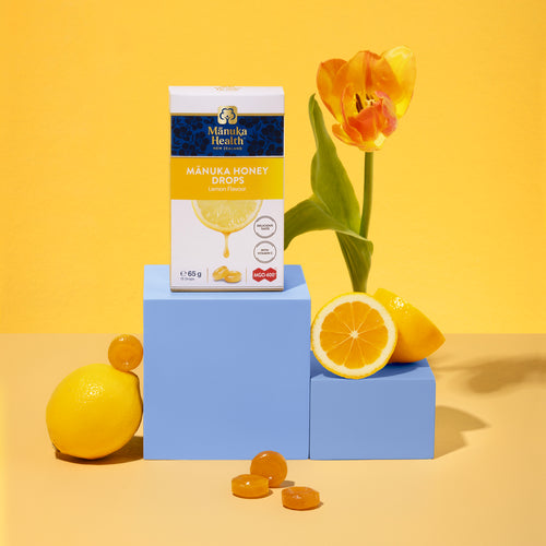 Manuka Health Manuka Honey Drops packaging with lemons and a tulip on a yellow background