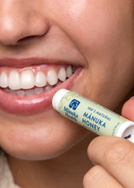 Person applying Manuka Health Mánuka Honey lip balm to their lips.