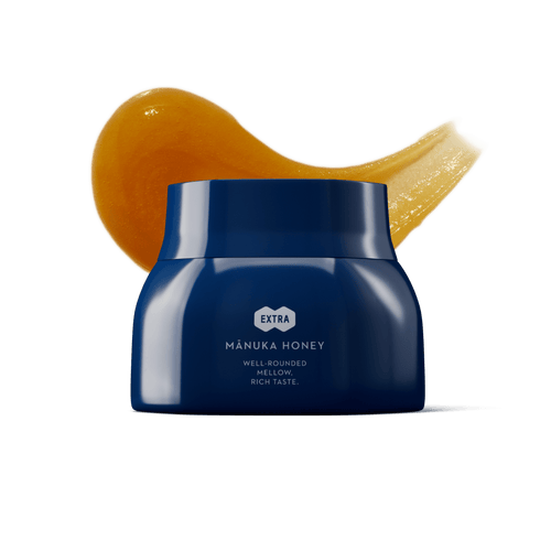 Blue jar of Manuka honey with a swatch of honey in the background.