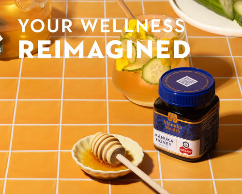 Manuka Health honey jar with honeycomb and dip on a grid-patterned surface, with text 'Your Wellness Reimagined'.